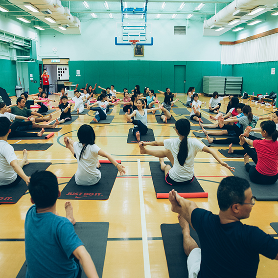 a group of people doing yoga in stadium