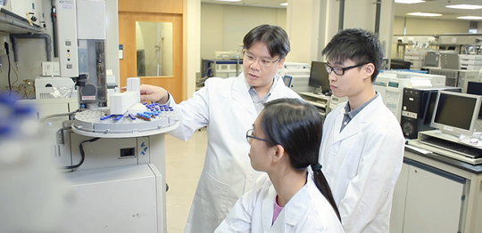 Professor discussing findings with research students in laboratory