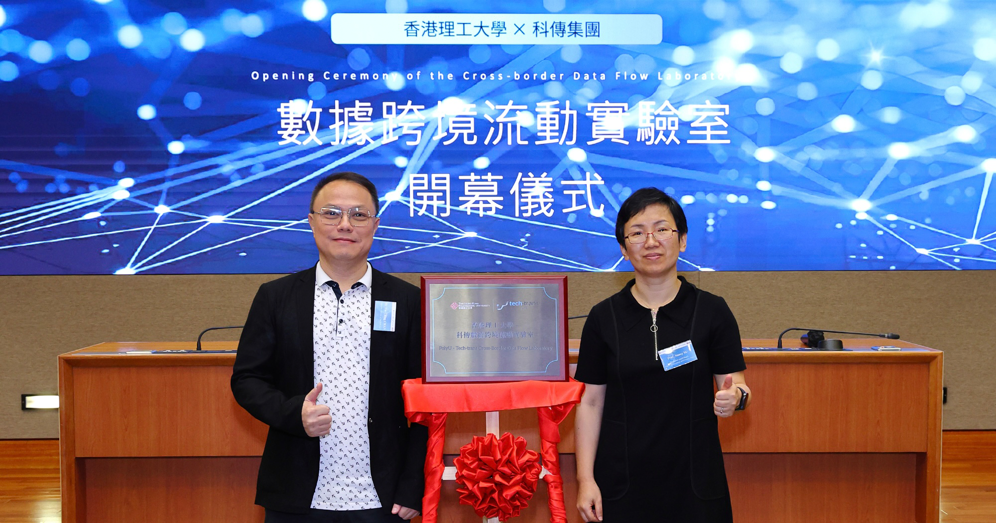 Mr. Yiuching Chan, Executive Director of Tech-Trans Group (Left) unveiled the plaque of the PolyU - Tech-Trans Cross-Border Data Flow Laboratory (CBDFL) with Prof. Nancy Su, Head of the School of Accounting and Finance (Right).