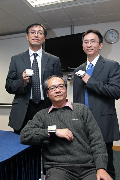 香港中風患者及家屬互助社新健社主席劉劍雄先生（中）是其中一位接受「提醒治療法」的患者，他佩戴了「感知提示手錶儀器」後可自行在家中練習，對患手的康復大有幫助。右為理大科技轉移及創業培育項目經理盧良成先生。