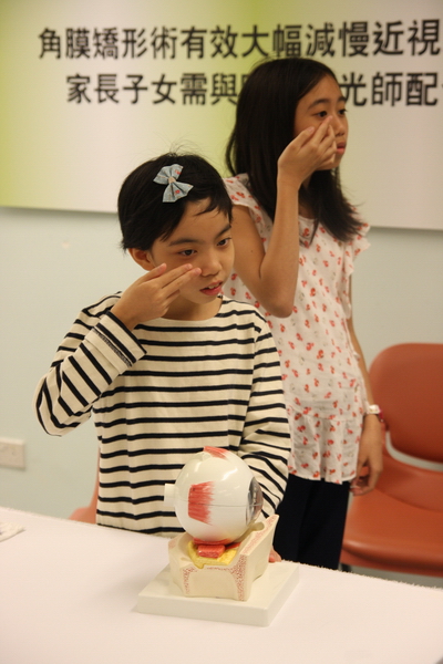 Two school children demonstrate how to wear Ortho-K lenses