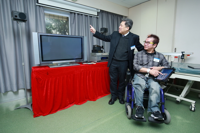 Ir Dr. Eric Tam and wheelchair user, Mr. Wong Wo-chau, demonstrate controlling curtain movement with iWheelchair.