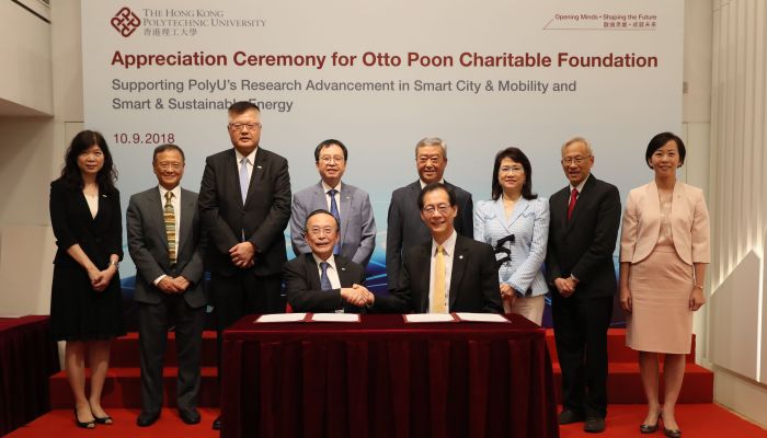 PolyU President Professor Timothy W. Tong (right, front row) and Ir Dr Otto Poon (left, front row) sign the donation agreement, witnessed by honorable guests.