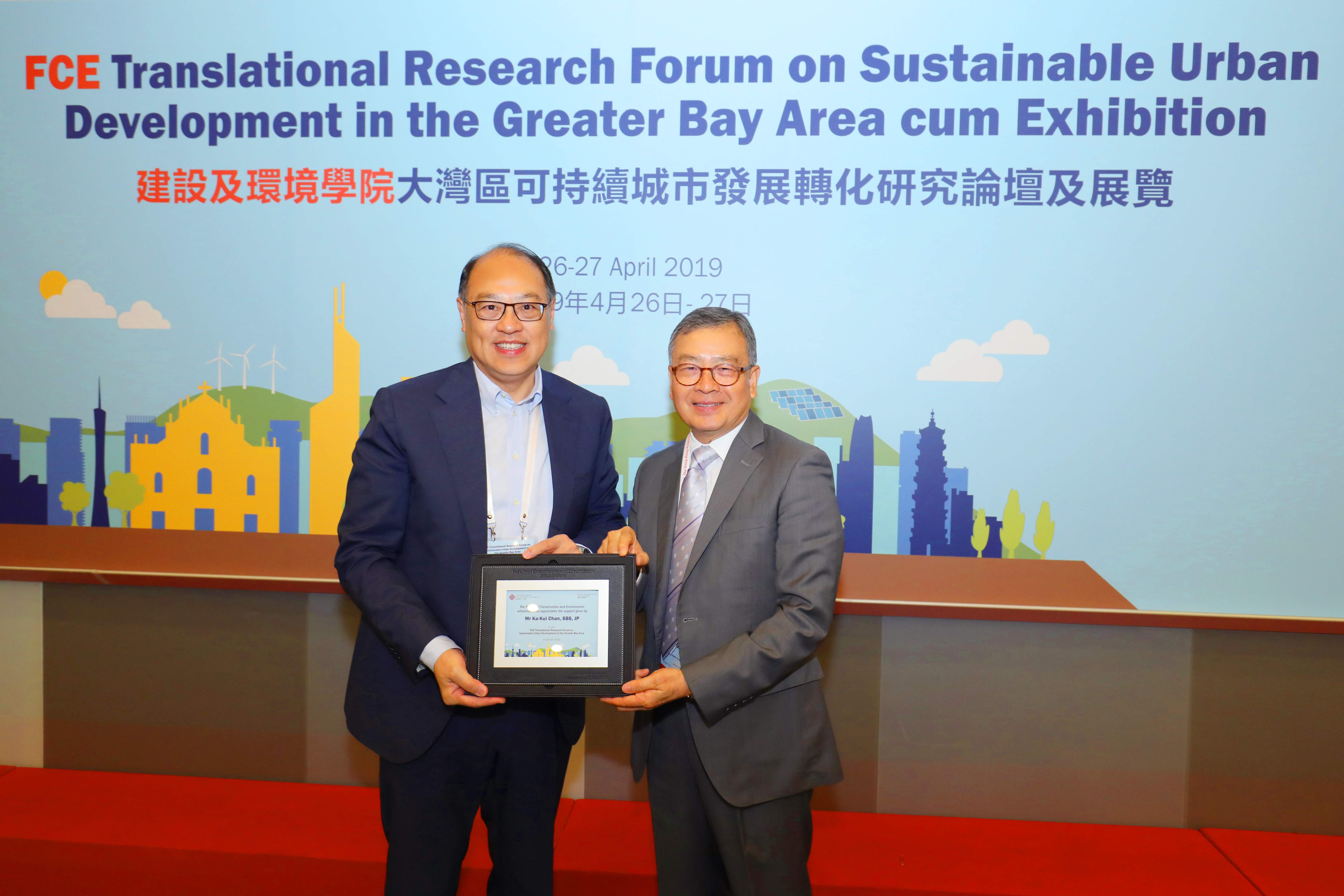 理大校董会主席林大辉博士(左)致送纪念品矛香港建造业议会主席陈家驹太平绅士。