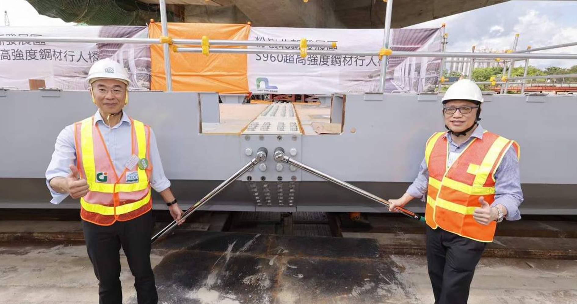 Prof. Kwok-fai Chung (right) with Mr FONG Hok Shing, Director of the Civil Engineering and Development Department (left). The photo shows the construction site of the Fanling North footbridge.