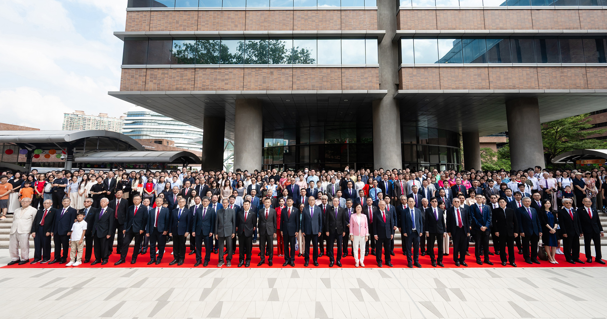 升旗仪式由理大校董会主席林大辉博士（右十三）、校长滕锦光教授（右十二）及中华人民共和国外交部驻香港特别行政区特派员公署政策研究室主任包海斌参赞（左十三）主礼。校董会副主席叶中贤博士（左十二）、大学顾问委员会主席颜吴余英博士（右十一）、大学司库李健先生（左十一）、大学顾问委员会荣誉主席钟志平博士（右十）、荣休校长潘宗光教授大紫荆勋贤（左十）、常务及学务副校长黄永德教授（右九）及高级副校长（研究及创新）赵汝恒教授（左九），联同一众理大校董会成员、大学顾问委员会成员、管理层、大学院士、杰出校友、理大基金会成员，以及逾1,300名嘉宾、师生和校友出席仪式