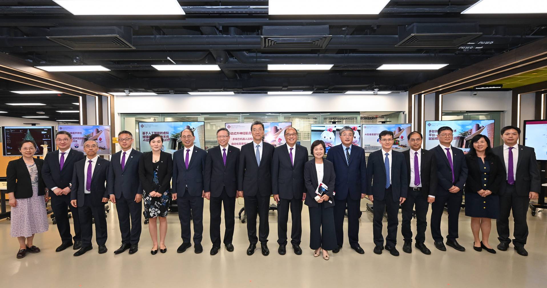 国家教育部部长怀进鹏先生（左八）、罗永纲先生（右六）、蔡若莲博士（右七）、林大辉博士（右八）、滕锦光教授（左七）、王伟明教授（右五）及黄永德教授（左六），与展示科研项目的理大学者合照，包括人工智能高等研究院执行院长、计算器及数学科学学院副院长（环球事务）及电子计算学系教授杨红霞教授（左五）、梁显利长者健康视觉教授及眼科视光学院科研眼科讲座教授何明光教授（左二）、生物医学工程学系讲座教授郑永平教授（右四）、医疗科技及信息学系系主任兼教授蔡璟教授（左四）、生物医学工程学系副教授胡晓翎教授（左一）、电子计算学系计算机视觉及图像分析讲座教授张磊教授（右三）、应用生物及化学科技学系副系主任兼教授赵燕湘教授（右二）、医疗科技及信息学系系统生物学与人工智能学讲座教授章伟雄教授（左三），以及应用生物及化学科技学系副教授兼马歇尔医学微生物学科技研究中心主任马聪教授（右一）。