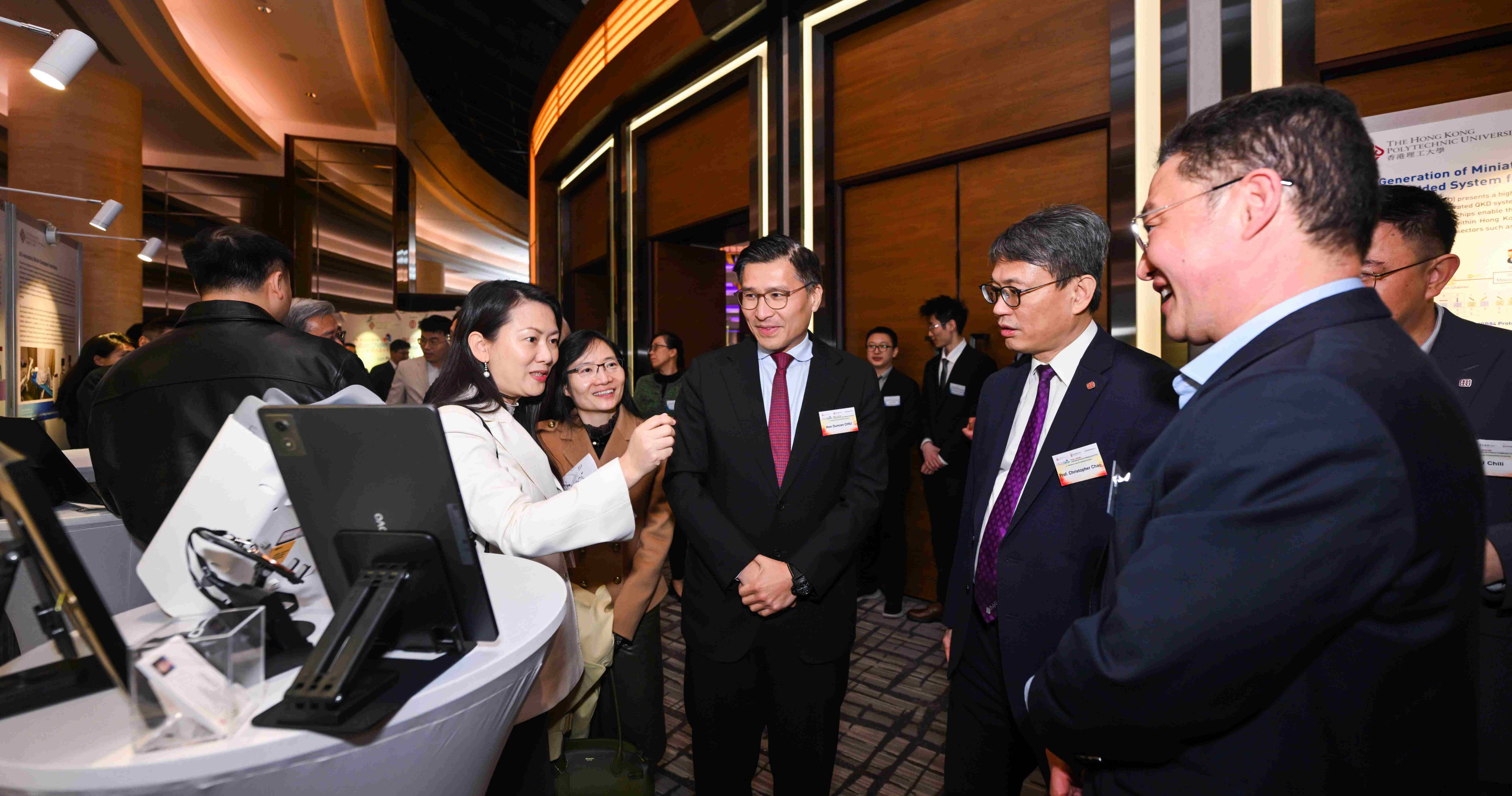 活动同场展出15个优秀初创项目，赵汝恒教授（右二）与陈翠芳女士（左一）向嘉宾中华人民共和国香港特别行政区立法会议员（科技创新界）邱达根议员（中）介绍参展项目。