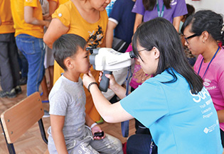 PolyU students and President Tong conducting eye checkup and vision screening for children in Tokmok.