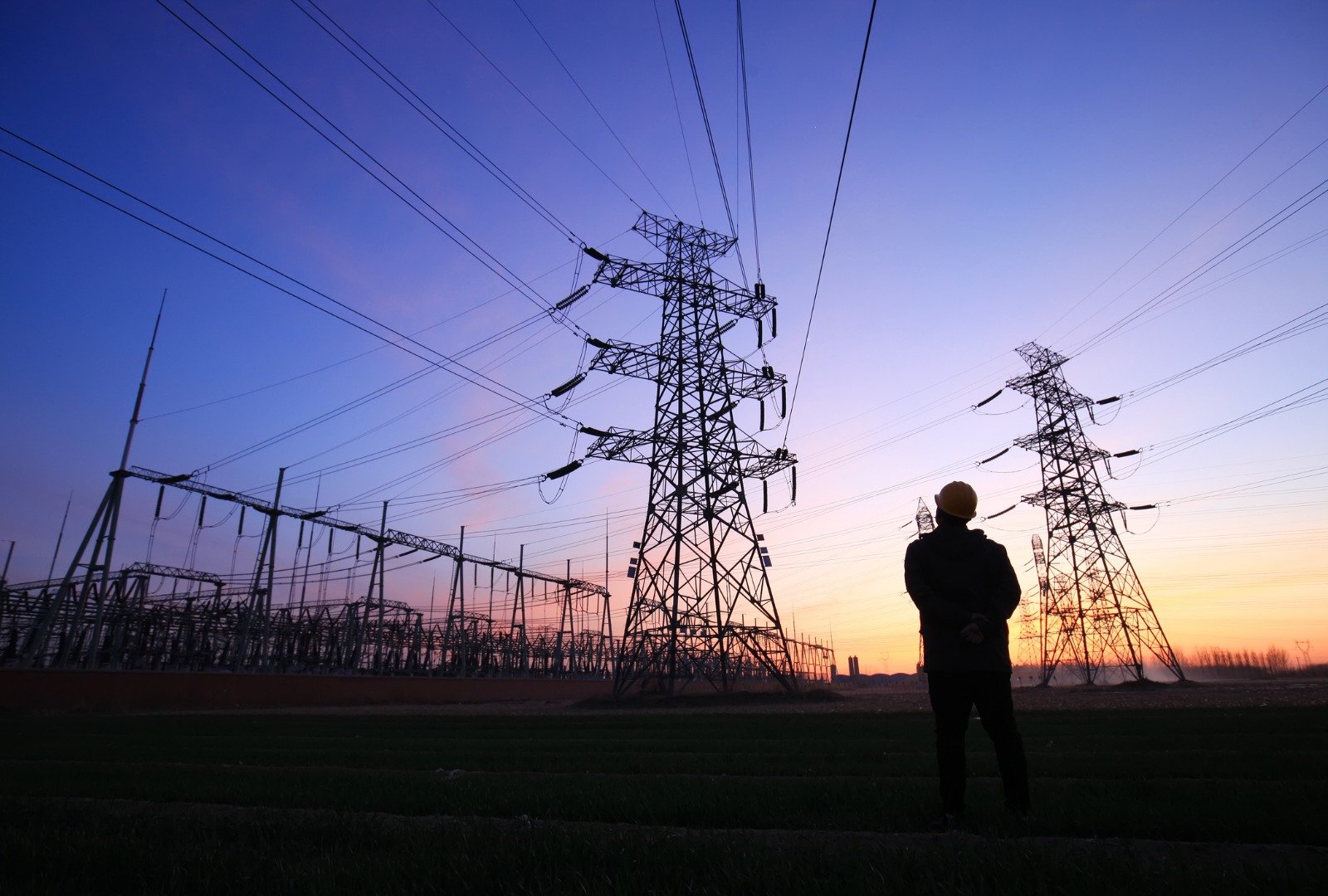 electricity-workers-and-pylon-silhouette-picture-id1252617520