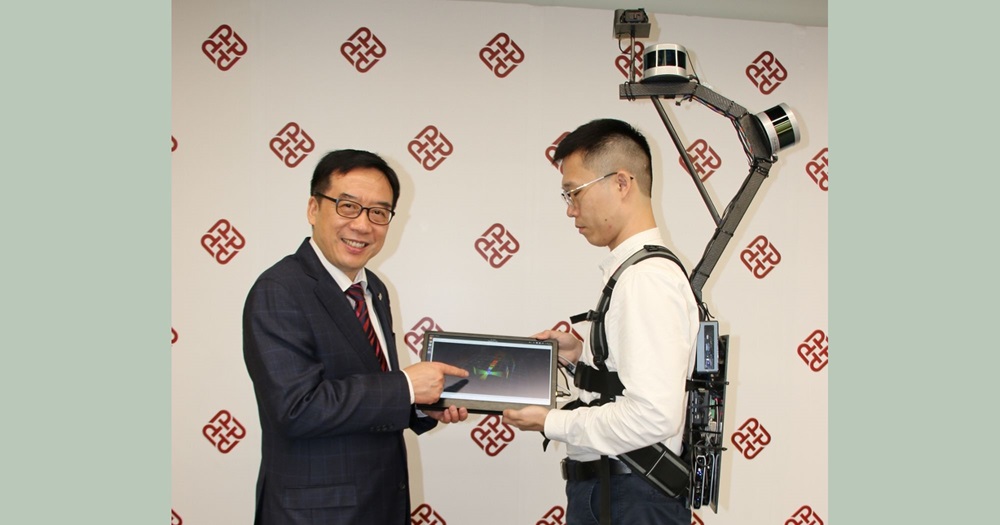 Professor John Shi (left) introduces the mobile mapping backpack. It can carry out continuous data collection in different complex indoor and outdoor environments, for measuring cities and obtaining 3D maps with centimeter-level, in support of wide smart cities applications.