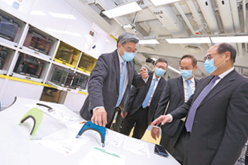 Professor H. C. Man (first left) explains how his team came up with the final design of the PolyU face shield to (from right) PolyU Council Chairman Dr Lam Tai-fai, Professor Alexander Wai, and President Jin-Guang Teng.