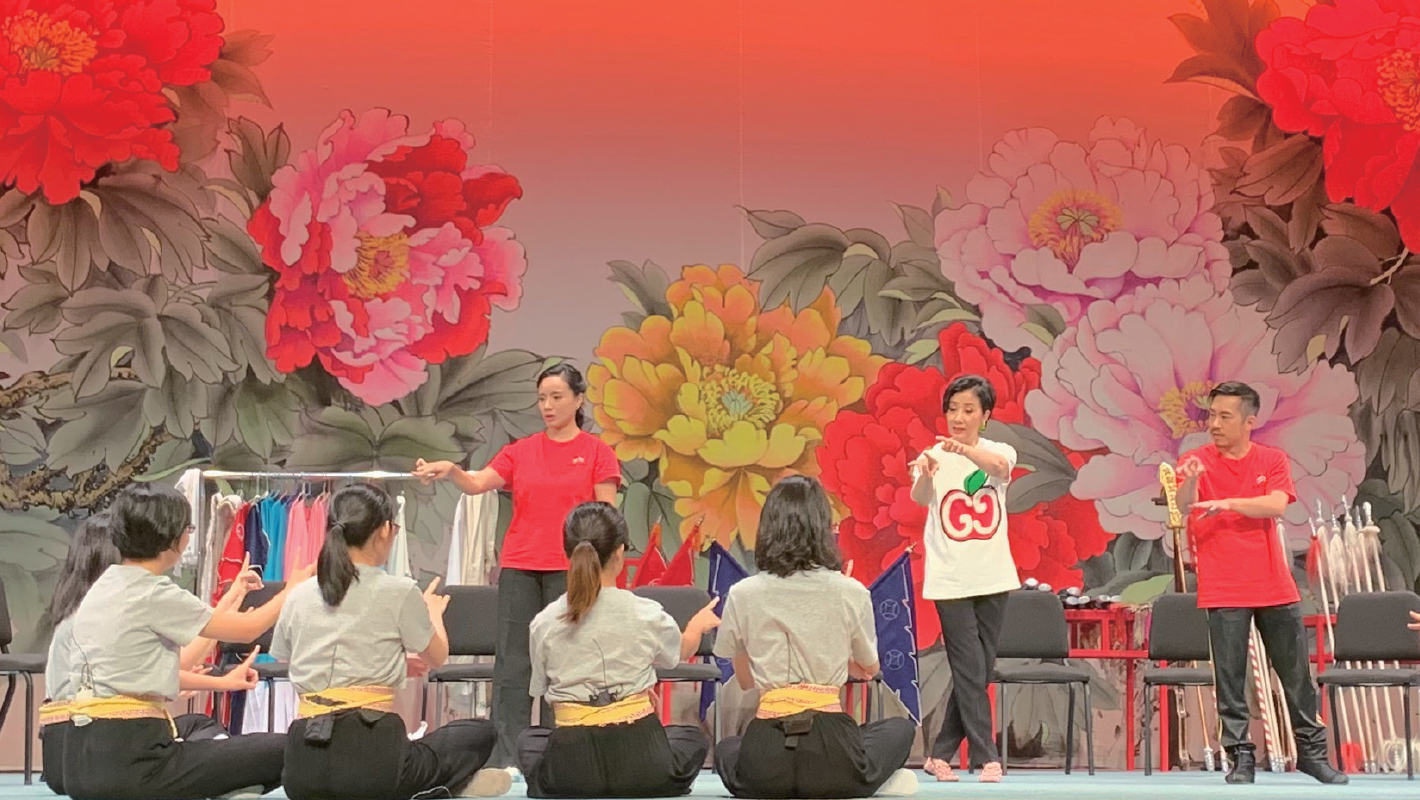 汪博士与学生分享粤剧知识，并教授表演技巧。