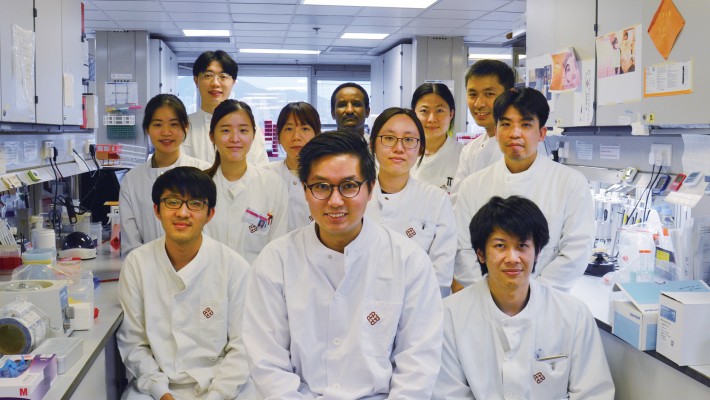 Dr Gilman Siu (front row, middle) and team members conduct genomic sequencing to identify COVID-19 transmission link.