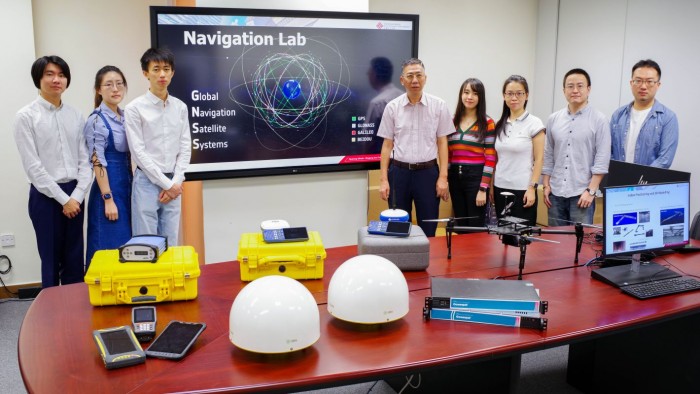 To achieve high positioning precision, Professor Chen Wu (fifth from right) and his research teamintegrated the measurements provided by multiple GNSSs.