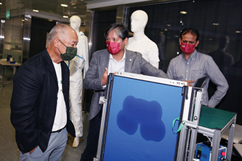 理大纤维科学与服装工程讲座教授范金土教授（右）演示排湿快干科技。