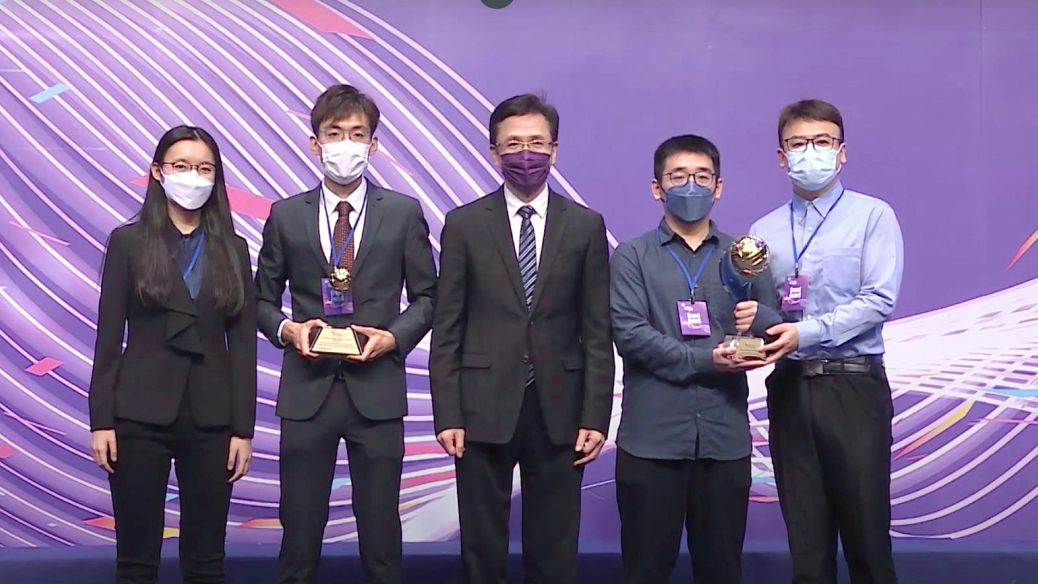 郭轩慈（左）、曾展乐（左二）、李成熙（右二）及郑湃博士（右）获创新科技及工业局局长孙东教授（中）颁发2022香港资讯及通讯科技奖奖项。