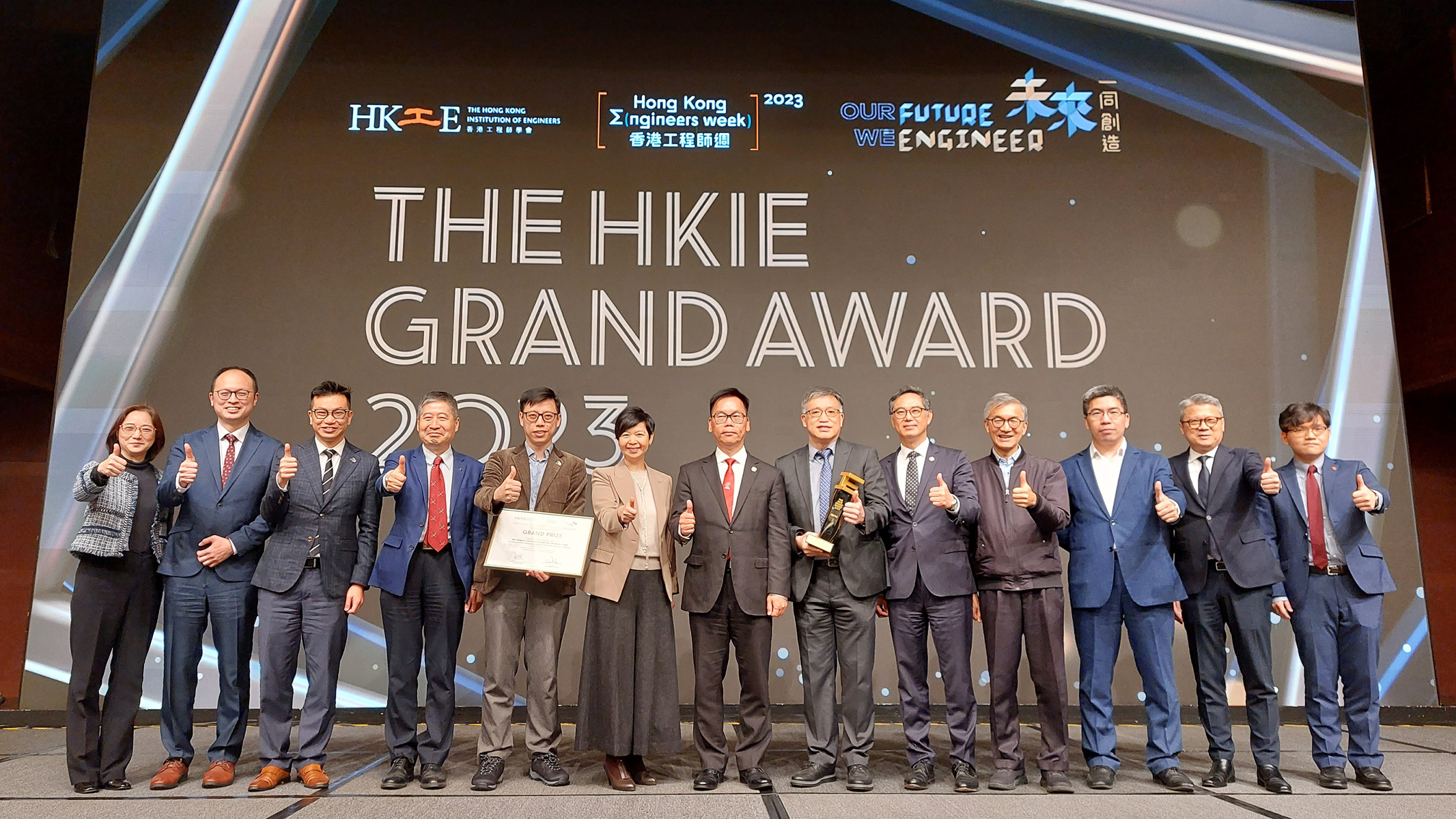 Members of PolyU showed their support when Professor Chung(sixth from right) received the HKIE Grand Award fromMs Winnie Ho, Secretary for Housing of HKSAR Government(sixth from left), and Ir Aaron Bok Kwok-ming, President ofHKIE (centre), on 9 March 2023.