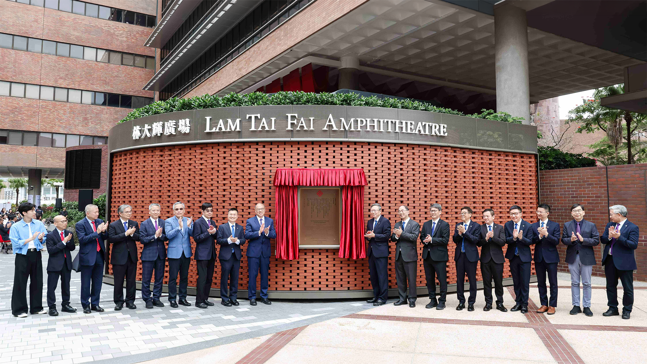 The unveiling ceremony of the Lam Tai Fai Amphitheatre was officiated by Dr Lam (left of the plaque) and Prof. Teng (right to the plaque), with members of the PolyU Council and central management team in attendance to mark the opening of this new campus cultural landmark.