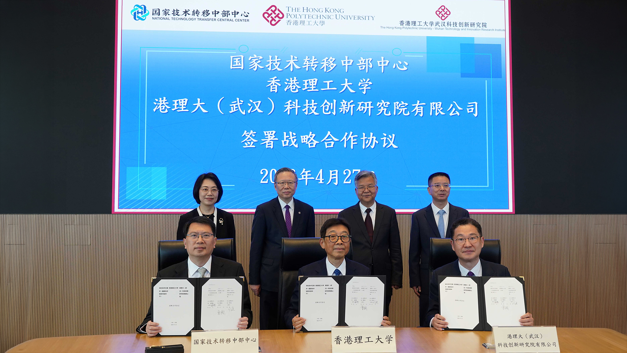 Witnessed by Mr Li Dianxun (back row, 2nd from right); Prof. Jin-Guang Teng (back row, 2nd from left); Ms Chen Ping (back row, 1st from left); and Mr Xiong Zhengyu (back row, 1st from right), a Tripartite Strategic Cooperation Agreement was signed by Prof. Cao Jiannong (front row, centre); Mr Sheng Jianxin, Director of the Hubei Technology Exchange (front row, left); and Prof. He Mingguang, Director of the PolyU-Wuhan Technology and Innovation Research Institute (front row, right).
