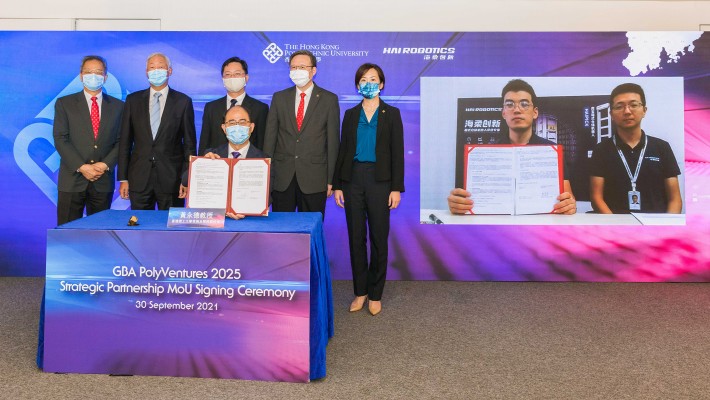 Professor Wing-tak Wong, Deputy President and Provost of PolyU (front), and Mr Richie Chen, CEO and Founder of Hai Robotics Co, Ltd (left on the screen), signed the “GBA PolyVentures 2025” Strategic Partnership MoU, witnessed by (starting from left at the back) Mr Richard Leung, PolyU Council Member, Dr Lawrence Li Kwok-chang, PolyU’s Deputy Council Chairman, Mr Alfred Sit, Secretary for Innovation and Technology of the HKSAR Government, Professor Jin-Guang Teng, PolyU President, Dr Miranda Lou, Executive Vice President of PolyU, and Mr Bing Fang, COO and Co-founder of Hai Robotics Co, Ltd (right on the screen).