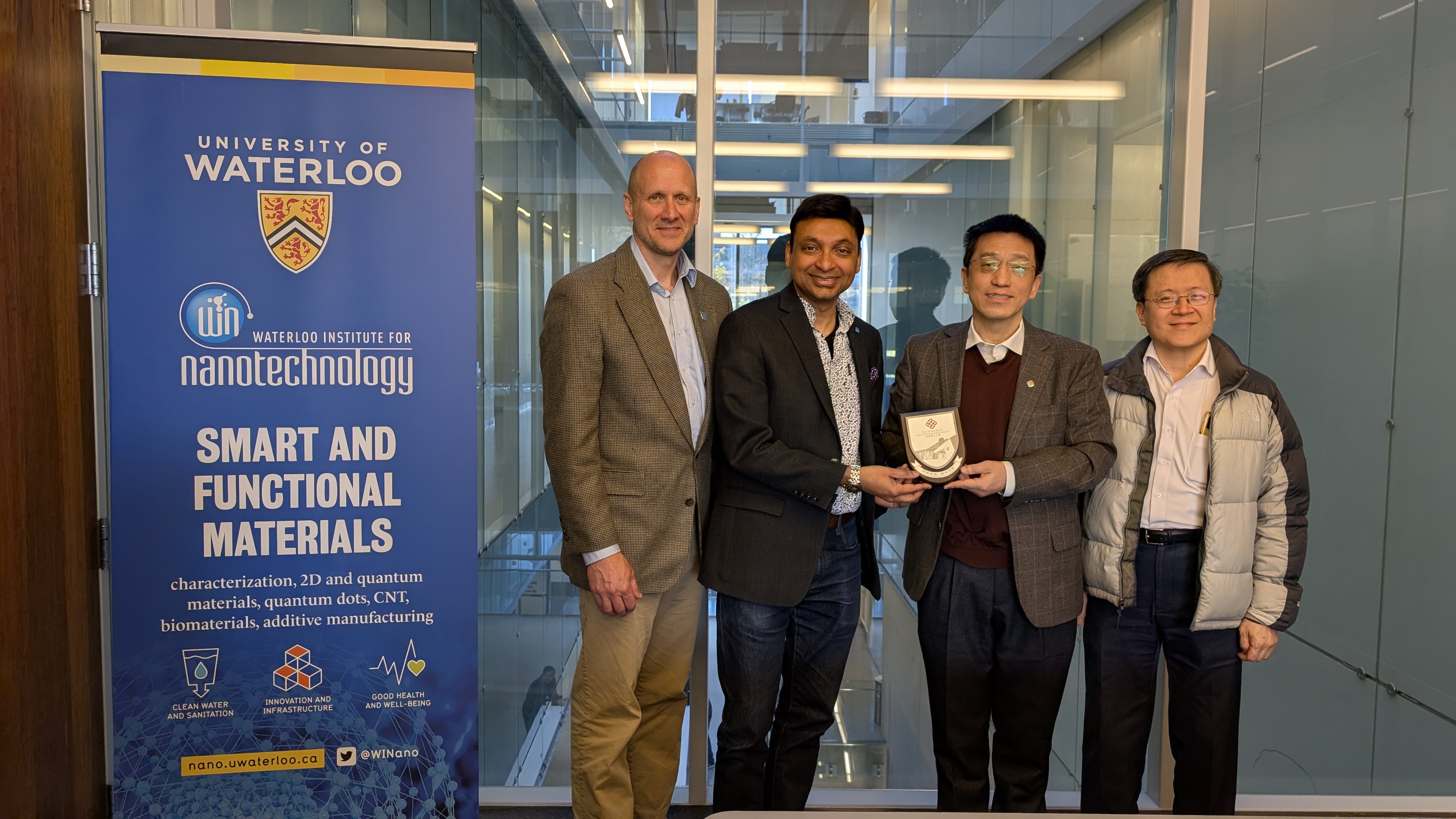 From left to right: Prof. Todd Holyoak (Associate Dean of the Faculty of Science, University of Waterloo), Prof. Sushanta Mitra (Executive Director, Waterloo Institute for Nanotechnology and RCNN Co-Director), Prof. Jianhua Hao (Director of RCNN, PolyU), and Prof. Raymond Wai-yeung Wong (Dean(FS), PolyU). Prof. Hao presents a PolyU wood shield to Prof. Mitra as a commemorative gift during the RCNN delegation’s visit to UW WIN.