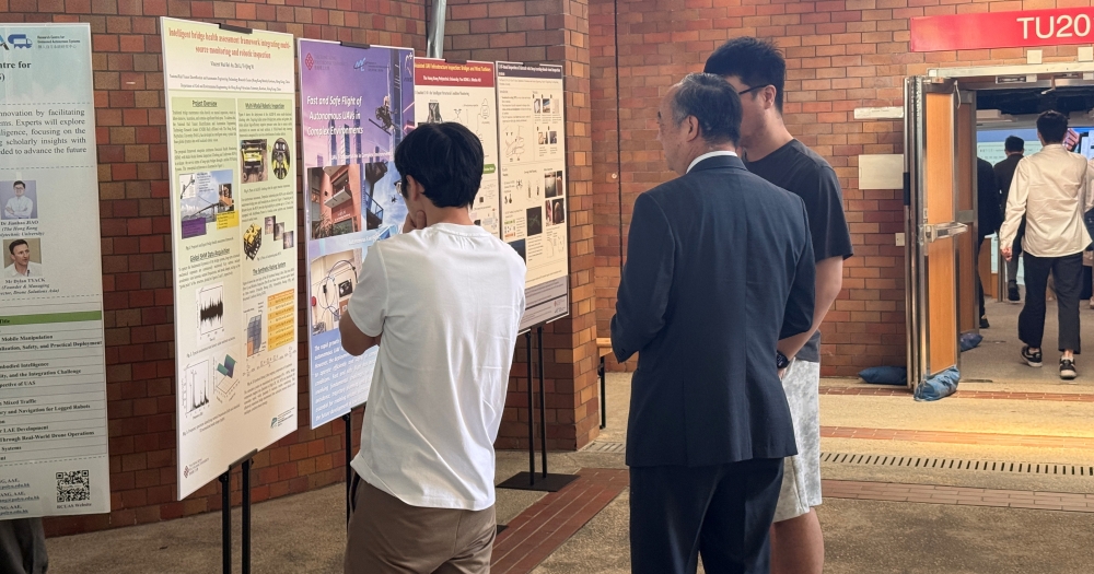 Prof. Wen Chih-Yung, Director of the RCUAS, discusses research ideas with students during the poster session at the 2nd Research Workshop of RCUAS.