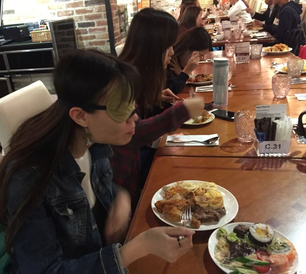 Enjoying food while experiencing challenges faced by those with visual impairment during Inclusion Awareness Banquet