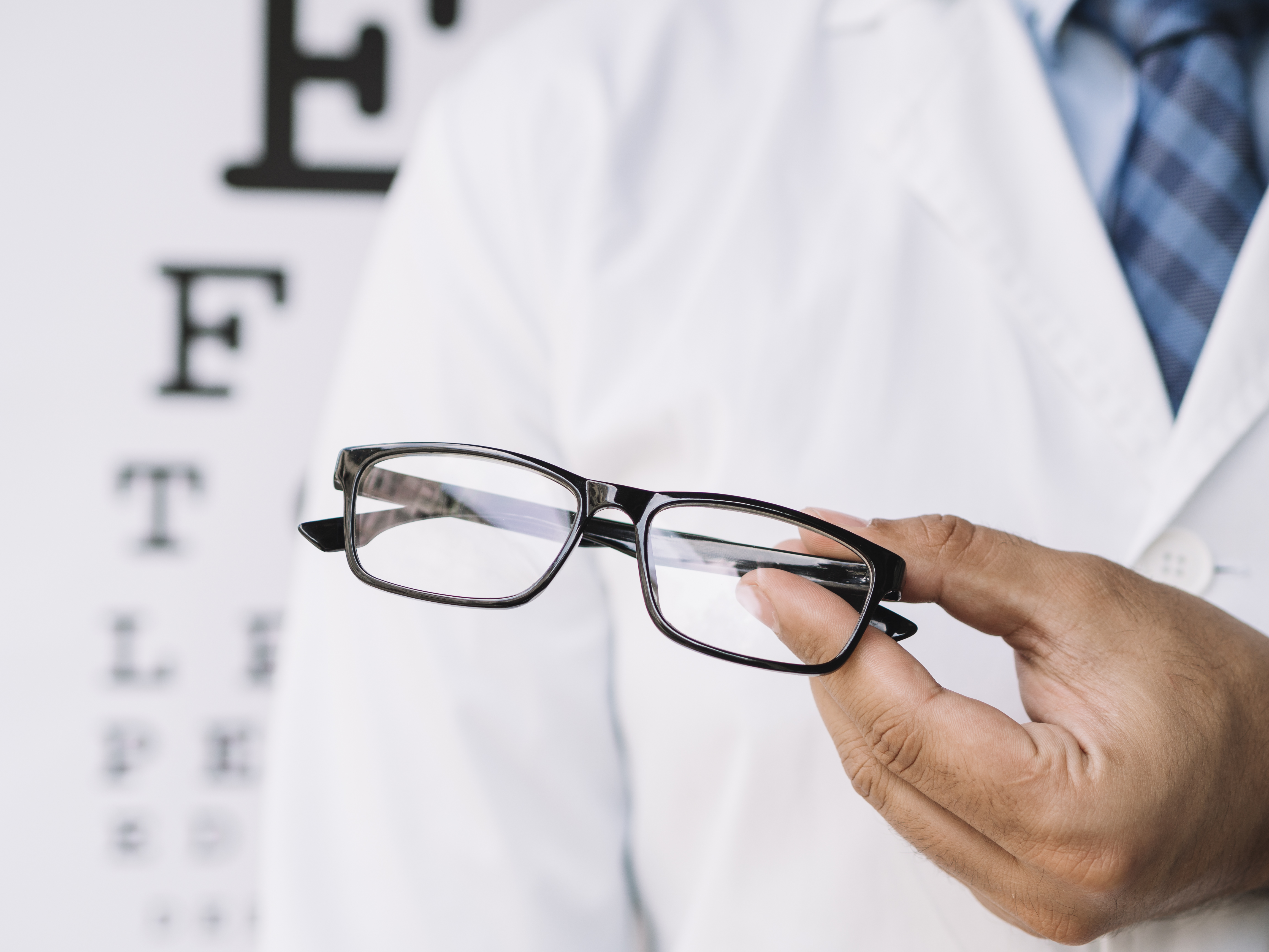 male-doctor-holding-pair-eyeglasses-his-hands