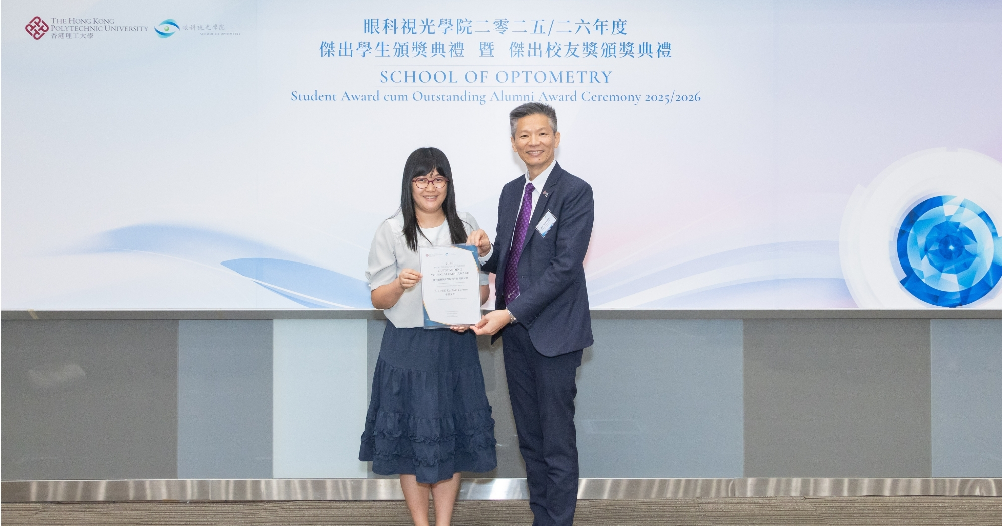 Dr Rita Sum (left) receives the 2026 Outstanding Young Alumni Award of PolyU School of Optometry on behalf of the awardee, Ms Carmen Lee, from Prof. Kee Chea-su, Head of the School.